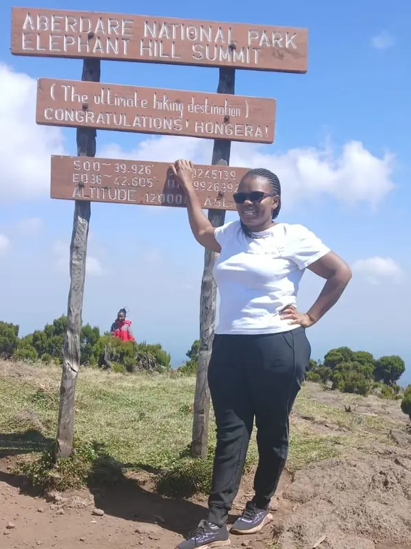Cypress Bush Explorers co-founder at the Elephant Hill summit sign in Aberdare National Park